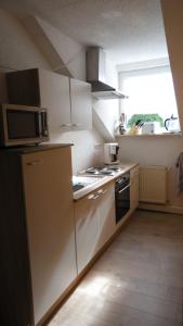 a kitchen with a microwave and a stove top oven at Ferienhaus und Privatvermietung Andrea Giesecke in Meiningen