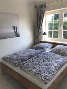 a bedroom with two beds and a window at Strandbungalow / Ferienhaus Ostsee in Scharbeutz