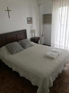 1 dormitorio con 1 cama grande y 2 toallas. en Depto. Baires en Buenos Aires