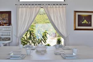 een witte tafel met witte gerechten en een groot raam bij Monte Abi Mirador in Chaguaní