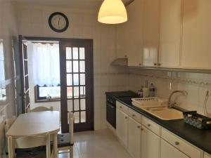 a kitchen with a table and a clock on the wall at Mira Maia Apartment in Maia
