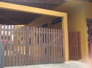 a wooden fence in front of a building at Trindade Hospeda - Estúdios Vila C in Trindade