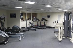 einen Fitnessraum mit mehreren Laufbändern und Maschinen in einem Zimmer in der Unterkunft Pearl Executive Hotel Apartments in Dubai
