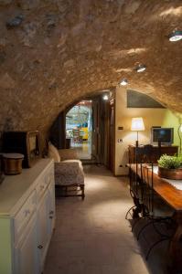 a kitchen with a stone wall and a living room at Charming rustic house in Gardone Riviera