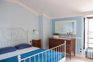 Schlafzimmer mit einem Bett, einer Kommode und einem Spiegel in der Unterkunft Charming rustic house in Gardone Riviera