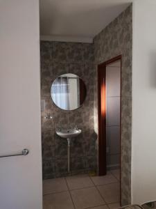 y baño con lavabo y espejo. en Upi guesthouse en Otjiwarongo