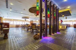 un restaurante con mesas, sillas y luces coloridas en Pearl Executive Hotel Apartments, en Dubái