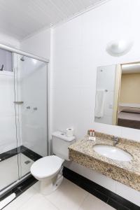 a bathroom with a toilet and a shower and a sink at Hotel Express Savoy Centro Histórico in Porto Alegre