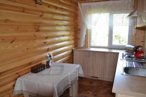 a kitchen with a table in a wooden wall at Липинський in Lipiny +9 photos
