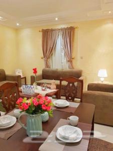 a living room with a table with flowers on it at Nadra Furnished Apartments in Taif