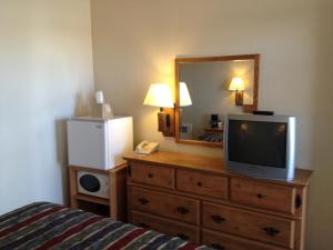 a bedroom with a television on a dresser with a mirror at The Monticello Inn in Monticello