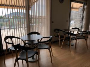 eine Gruppe von Tischen und Stühlen in einem Zimmer mit Fenstern in der Unterkunft Hotel Río Hortega in Valladolid