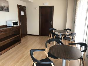 a room with two tables and chairs and a microwave at Hotel Río Hortega in Valladolid