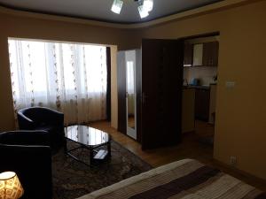 a living room with a bed and a glass table at Near center in Petroşani