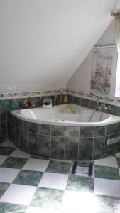 a bath tub in a room with a tiled floor at Messe- und Gästezimmer in Hannover