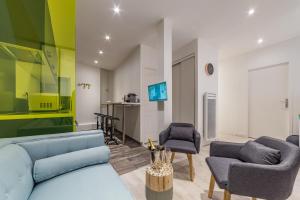 a living room with a blue couch and two chairs at Appartement Cottage centre ville Clémenceau - APPART EVASION in Pau