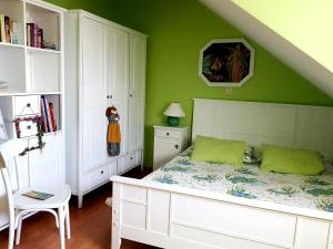 a bedroom with a white bed and green walls at Apartment Silvia in Kaštela