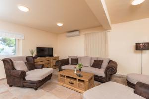 a living room with two couches and a tv at Villa Sandra in Lumbarda