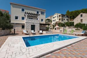 a swimming pool in front of a house at Villa Sandra in Lumbarda