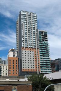 ein hohes Gebäude in einer Stadt mit Gebäuden in der Unterkunft Atlantis Hotel Melbourne in Melbourne