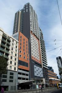 a tall building in the middle of a city at Atlantis Hotel Melbourne in Melbourne