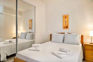 een slaapkamer met 2 bedden en een spiegel bij Vilamoura WOWlidays in Vilamoura
