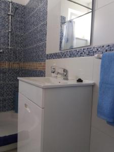 Baño blanco con lavabo y espejo en Casa Sol, en Carrapateira