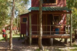 a tree house with a hammock in the woods at Ligustrum House in Punta Del Diablo