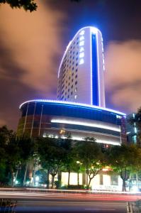 Gubei Garden Hotel Shanghai Hongqiao في شانغهاي: مبنى طويل وبه أضواء زرقاء في الليل