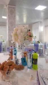 a table with a vase with flowers on it at Pensiunea Jacqueline in Târgu Jiu