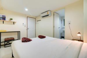 a bedroom with a white bed and a fireplace at Red Pin Inn 好运旅馆 in Bangkok