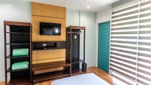 a room with a tv and a closet at Sea Cocoon Hotel in El Nido