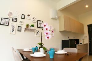 a dining room table with a pink flower on the wall at RELAX & COZY HOME @ MIDHILLS GENTING in Genting Highlands