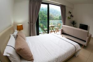 a bedroom with a white bed and a large window at RELAX & COZY HOME @ MIDHILLS GENTING in Genting Highlands +19 photos