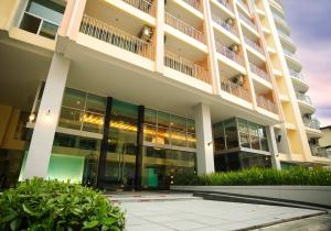 an external view of a building with large windows at Golden Pearl Hotel in Bangkok