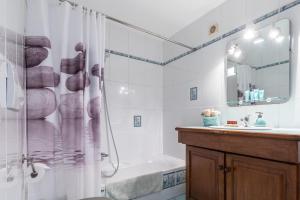 a bathroom with a shower and a tub and a sink at La maison des vacances in Menton +33 photos