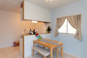 a small kitchen with a table and a refrigerator at Snow ball Condominium in Kin