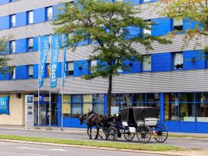 eine Pferdekutsche vor einem Gebäude in der Unterkunft Ibis budget Wien Sankt Marx in Wien