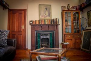 a living room with a fireplace and a couch at Huys ten Bosch in Potchefstroom