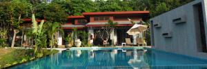 a swimming pool in front of a house at Arthaya Villas - SHA Extra Plus in Ko Lanta