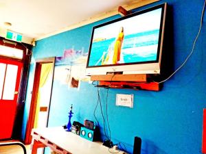 a flat screen tv hanging on a blue wall at St Kilda East backpackers' hostel in Melbourne