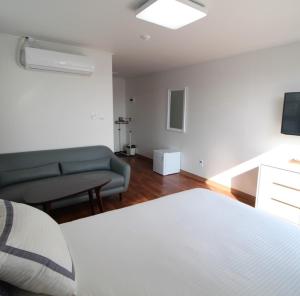 um quarto com uma cama, um sofá e uma televisão em Guest 145 em Gwangju