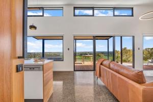 a living room with a couch and windows at Shadow Creek McLaren Vale in McLaren Vale