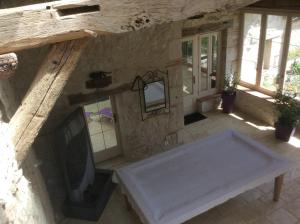 a living room with a fireplace in a stone building at Le Bois de Montpouillan in Montpouillan