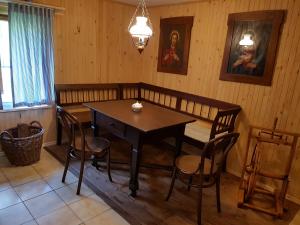 a dining room with a wooden table and chairs at Palčovka Huty - apartmán U Ondry a U Andělky in Huty