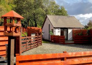 a barn with a fence and a gate and a building at The Wee Ludging Cottage, Rashfield, by Dunoon in Dunoon