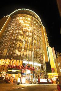 een groot gebouw wordt 's nachts verlicht bij Sauna & Capsule AMZA (mens only) in Osaka