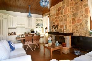a kitchen and living room with a stone wall at Bella's Rustic Suites in Nafplio