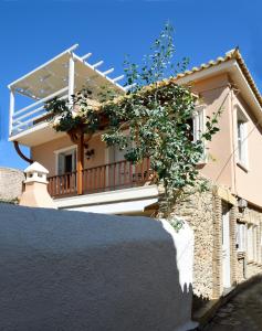 a house with a balcony and a stone wall at Nafplio Place in Nafplio