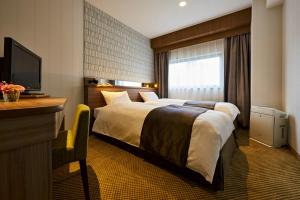 Postel nebo postele na pokoji v ubytování Sendai Kokusai Hotel